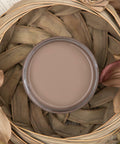 Dixie Belle Paint Mud Puddle Chalk Mineral Paint is the perfect paint for any DIY project! Top View of brown paint siting inside wicker basket with flowers.