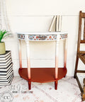 Dixie Belle Paint Muscadine Wine Chalk Mineral Paint is the perfect paint for any DIY project! White, pink and dark red chalk painted end table with floral decoupage paper. Staged with books.