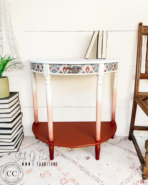 Dixie Belle Paint Muscadine Wine Chalk Mineral Paint is the perfect paint for any DIY project! White, pink and dark red chalk painted end table with floral decoupage paper. Staged with books.