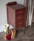 Dixie Belle Paint Muscadine Wine Chalk Mineral Paint is the perfect paint for any DIY project! Dark red chalk painted end table blended with black. Staged with books and candle sticks.