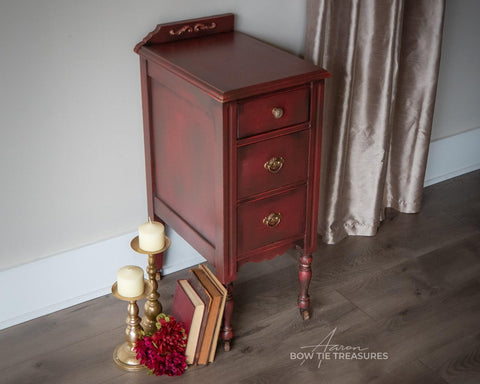 Dixie Belle Paint Muscadine Wine Chalk Mineral Paint is the perfect paint for any DIY project! Dark red chalk painted end table blended with black. Staged with books and candle sticks.