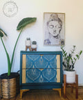 Dixie Belle Paint Palmetto Chalk Mineral Paint is the perfect paint for any DIY project! Green chalk painted bedside table with gold art deco accents on the front, and gold legs. Staged with potted plants.
