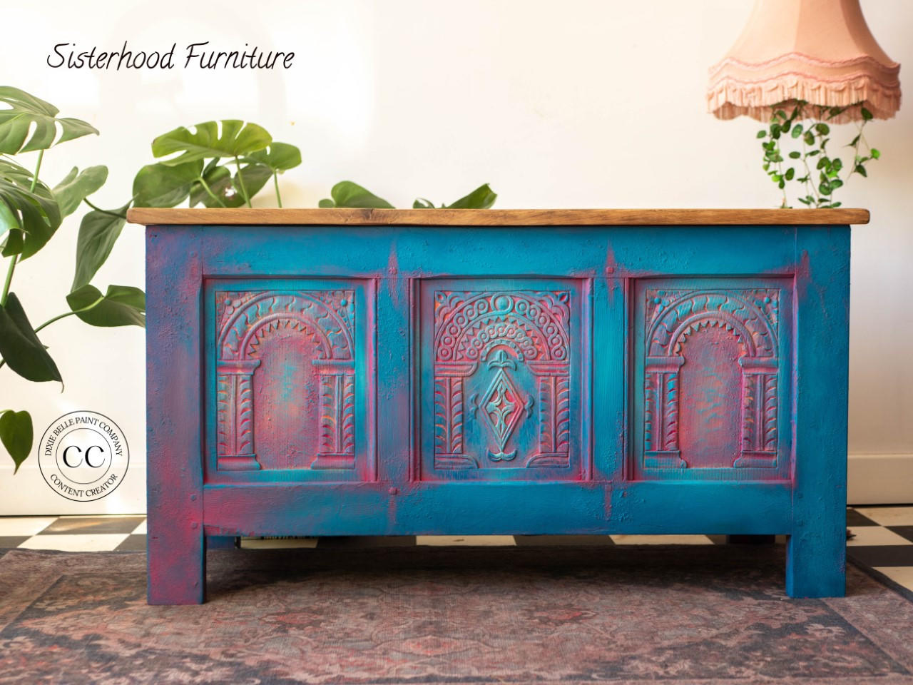 Dixie Belle Paint Peacock Chalk Mineral Paint is the perfect paint for any DIY project! Blue chalk painted blanket box blended with pink chalk paint with a wood top. Staged with plants.