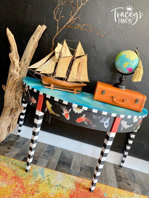 Dixie Belle Paint Peacock Chalk Mineral Paint is the perfect paint for any DIY project! end table painted black with black and white stripe legs, blue chalk paint on the top and koi rub on transfers.