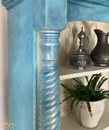 Dixie Belle Paint Pearlescent Glaze. Up-close of a Blue chalk painted piece of furniture with Pearlescent Glaze. Staged with a plant and some metal pitchers,