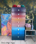 Dixie Belle Paint Pearlescent Glaze. Colorful rainbow chalk painted tall skinny dresser with Pearlescent Glaze painted on. Staged with colorful flowers.