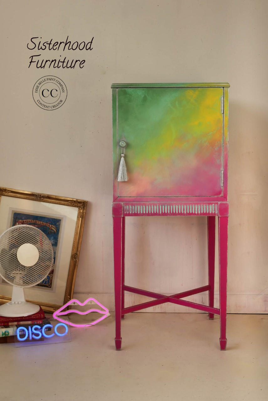 Dixie Belle Paint Peony Chalk Mineral Paint is the perfect paint for any DIY project! Pink, yellow and green chalk painted Ombre tall end table cabinet Staged next to neon signs and a fan.