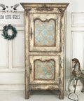 Dixie Belle Paint Pine Cone Chalk Mineral Paint is the perfect paint for any DIY project! Light brown Chalk mineral painted armoire distressed to make look chippie. Blue scroll style stencil painted on the front doors. Staged with a wreath and a vintage horse statue.