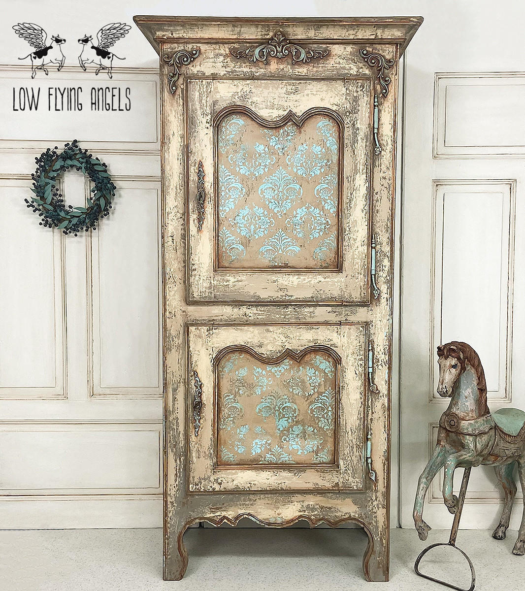 Dixie Belle Paint Pine Cone Chalk Mineral Paint is the perfect paint for any DIY project! Light brown Chalk mineral painted armoire distressed to make look chippie. Blue scroll style stencil painted on the front doors. Staged with a wreath and a vintage horse statue.