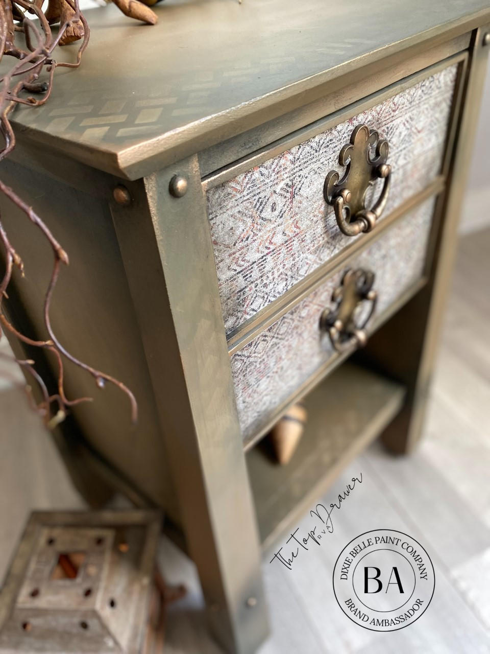 Dixie Belle Paint Pine Cone Chalk Mineral Paint is the perfect paint for any DIY project! Light brown Chalk mineral paint end table close up with a gold painted stencil design up top and decoupage paper on the drawer.