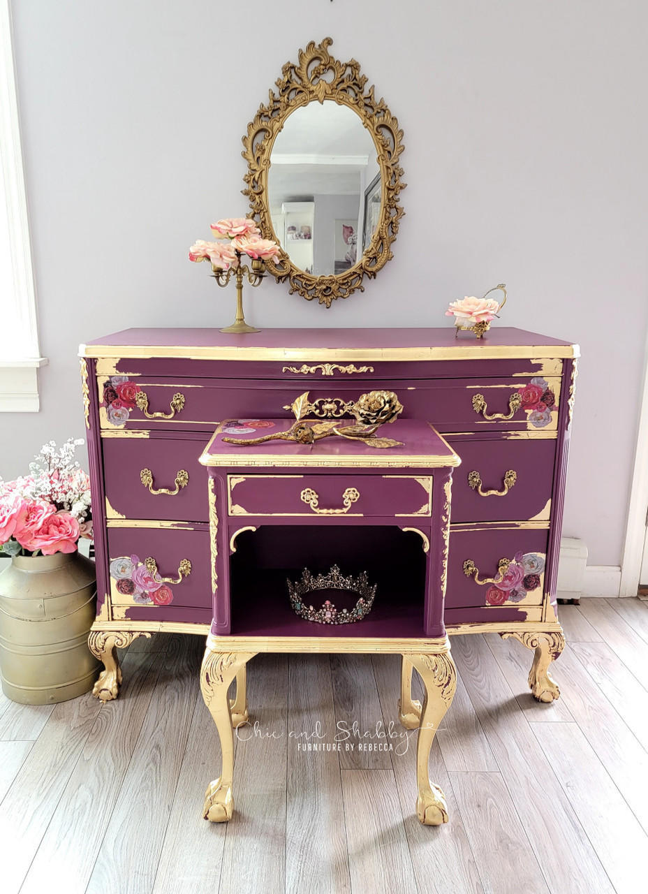 Dixie Belle Paint Plum Crazy Chalk Mineral Paint is the perfect paint for any DIY project! Dresser and end table painted in a maroon chalk paint with gold feet, gold hardware and gold trim. Staged with pink flowers, a tiara and a gold mirror.