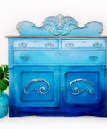 Dixie Belle Paint Pure Ocean Chalk Mineral Paint is the perfect paint for any DIY project! dark blue to light blue Ombre chalk painted cabinet with glass vase and a leaf.
