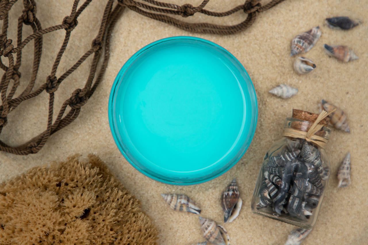 Dixie Belle Paint Pure Ocean Chalk Mineral Paint is the perfect paint for any DIY project! Top view of open light blue paint can staged with sea shells, sponge, and rope.