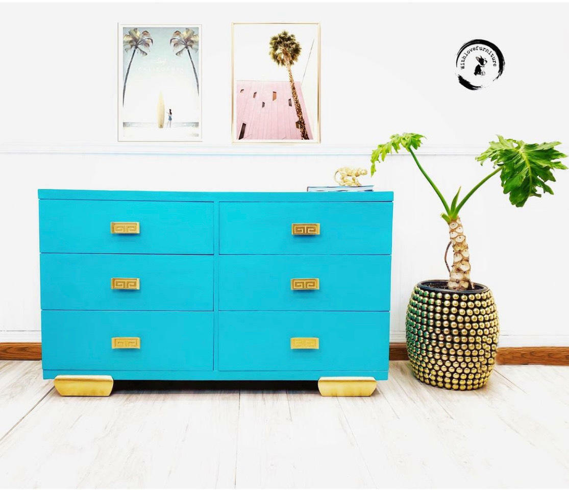 Dixie Belle Paint Pure Ocean Chalk Mineral Paint is the perfect paint for any DIY project! Blue chalk painted dresser with gold feet and gold hardware. Staged next to a plant in a vase.
