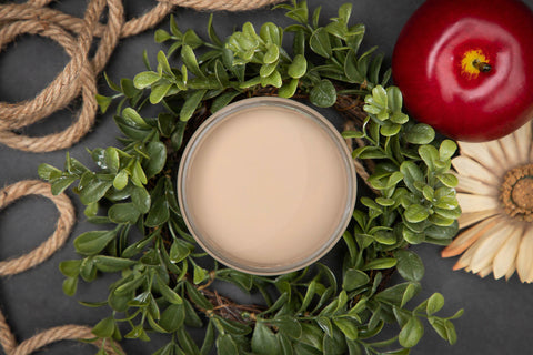 Dixie Belle Paint Putty Chalk Mineral Paint is the perfect paint for any DIY project! Top view of an open jar of paint staged with greenery, rope and an apple surrounding the jar of paint.