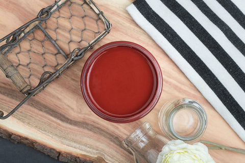 Dixie Belle Paint Rustic Red Chalk Mineral Paint is the perfect paint for any DIY project! A staged image of an open paint jar featuring the rustic red shade.