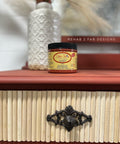 Dixie Belle Paint Rusty Nail Chalk Mineral Paint is the perfect paint for any DIY project! An closeup image of the rusty nail jar of paint on top of a vanity painted in rusty red.
