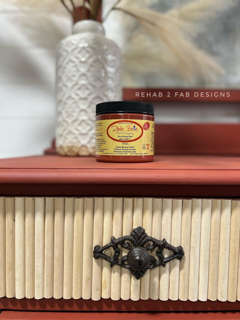 Dixie Belle Paint Rusty Nail Chalk Mineral Paint is the perfect paint for any DIY project! An closeup image of the rusty nail jar of paint on top of a vanity painted in rusty red.