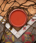 Dixie Belle Paint Rusty Nail Chalk Mineral Paint is the perfect paint for any DIY project! A staged image of an open paint jar featuring the deeper red known as rusty nail.