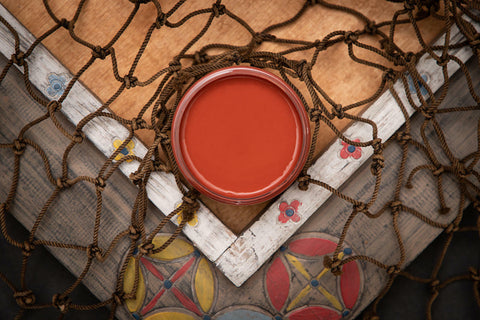 Dixie Belle Paint Rusty Nail Chalk Mineral Paint is the perfect paint for any DIY project! A staged image of an open paint jar featuring the deeper red known as rusty nail.