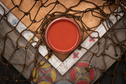 Dixie Belle Paint Rusty Nail Chalk Mineral Paint is the perfect paint for any DIY project! A staged image of an open paint jar featuring the deeper red known as rusty nail.