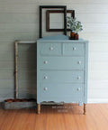 Dixie Belle Paint Savannah Mist Chalk Mineral Paint is the perfect paint for any DIY project! A tall dresser that is painted in the light blue color, savannah mist. This dresser has 2 small drawers on top and 3 long drawers towards the bottom.