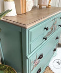 Dixie Belle Paint Sea Glass Chalk Mineral Paint is the perfect paint for any DIY project! A dresser painted in sea glass with a natural wooden top and a peacock transfer on the front.