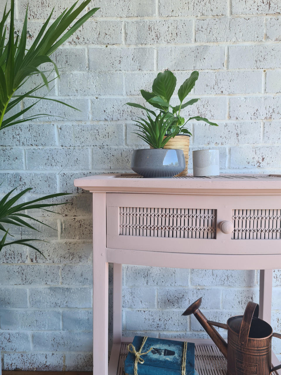 Dixie Belle Paint Soft Pink Chalk Mineral Paint is the perfect paint for any DIY project! A simple side table painted in soft pink chalk mineral paint and has a rattan type of design on the front single drawer.