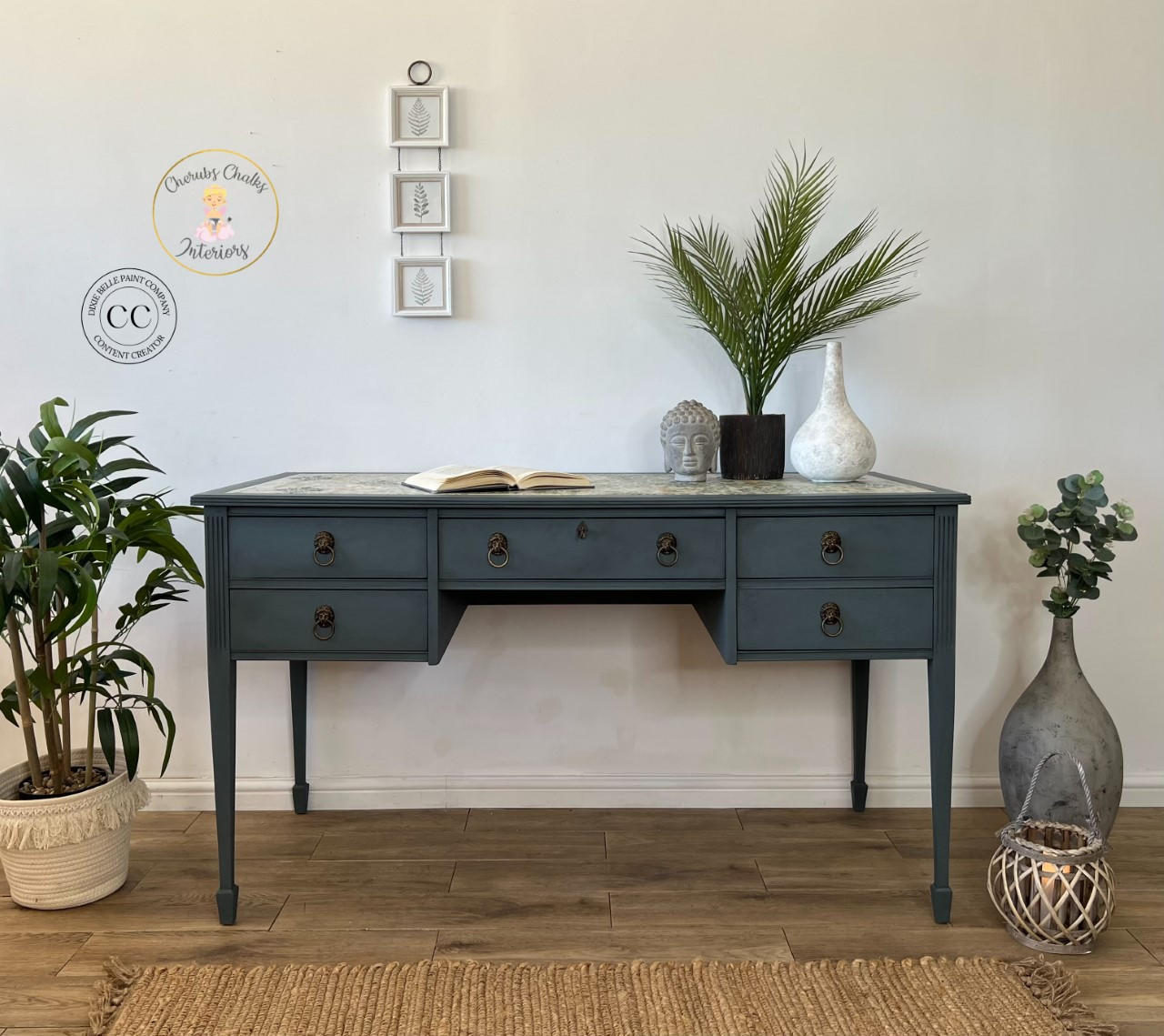 Dixie Belle Paint Stormy Seas Chalk Mineral Paint is the perfect paint for any DIY project!
Office desk painted in Stormy Seas Chalk Mineral Paint with bronze hardware. Staged with different pottery and greenery.