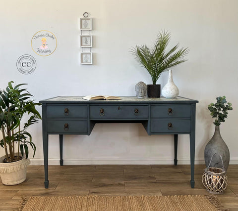 Dixie Belle Paint Stormy Seas Chalk Mineral Paint is the perfect paint for any DIY project!
Office desk painted in Stormy Seas Chalk Mineral Paint with bronze hardware. Staged with different pottery and greenery.