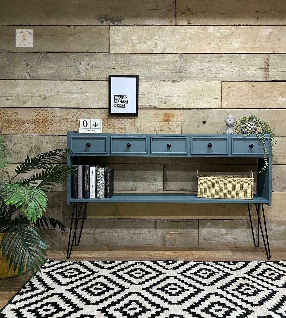 Dixie Belle Paint Stormy Seas Chalk Mineral Paint is the perfect paint for any DIY project!
Console table painted in Stormy Seas Chalk Mineral Paint with black legs and hardware. Staged with greenery, books and a woven basket.