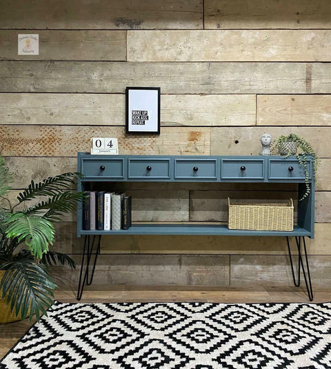Dixie Belle Paint Stormy Seas Chalk Mineral Paint is the perfect paint for any DIY project!
Console table painted in Stormy Seas Chalk Mineral Paint with black legs and hardware. Staged with greenery, books and a woven basket.