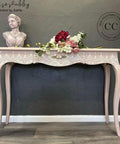 Dixie Belle Paint Tea Rose Chalk Mineral Paint is the perfect paint for any DIY project!
Entrance table painted in Tea Rose Chalk Mineral Paint with Lotus Bloom - Stencil along the front drawer. Staged with flowers and torso statue of a women on top of piece.