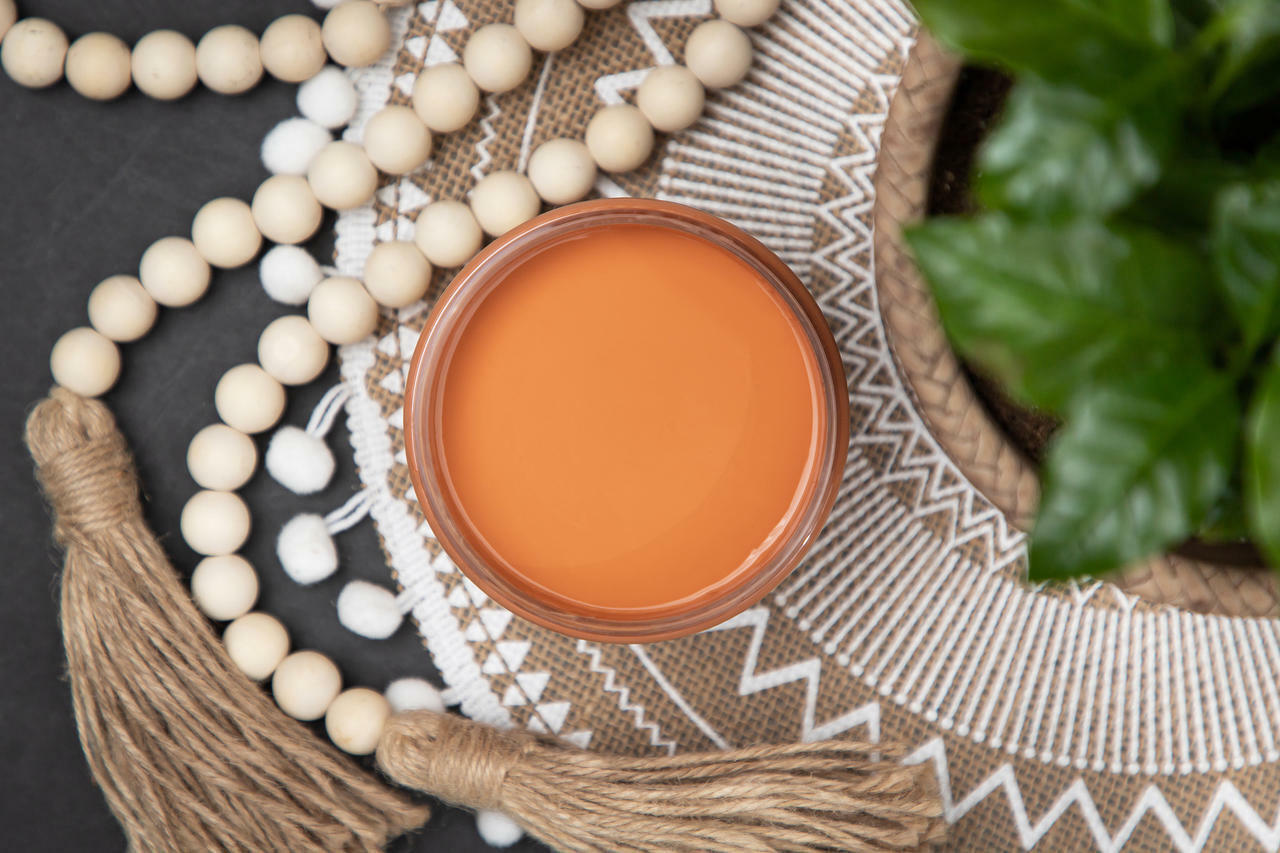 Dixie Belle Paint Terracotta Chalk Mineral Paint is the perfect paint for any DIY project!  An open jar of Dixie Belle Paint Terracotta Chalk Mineral Paint sitting on a table with beads and tassels.