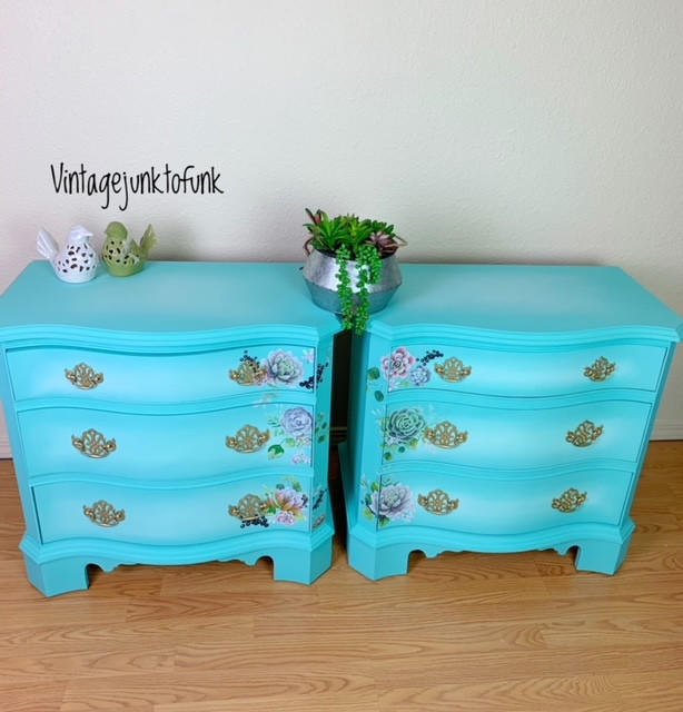 Dixie Belle Paint The Gulf Chalk Mineral Paint is the perfect paint for any DIY project!  A pair of blue chalk painted nightstands with gold hardware and flower rub-on transfers applied to each drawer.