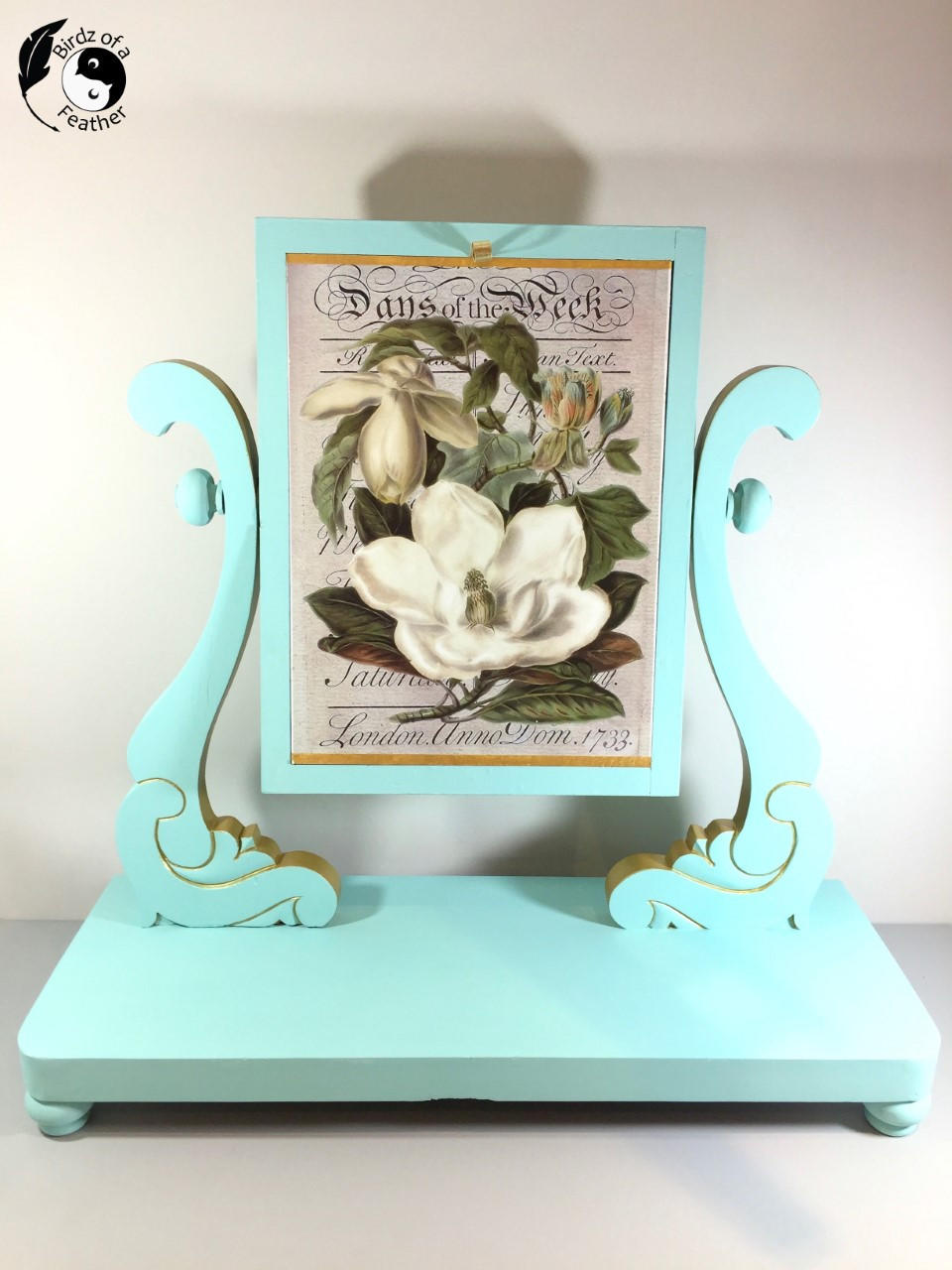 Dixie Belle Paint The Gulf Chalk Mineral Paint is the perfect paint for any DIY project!  A blue chalk painted picture stand holding a printed picture of a white flower.