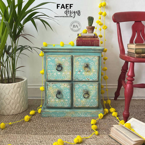 Dixie Belle Paint The Gulf Chalk Mineral Paint is the perfect paint for any DIY project!  A blue chalk painted corner table with a design stenciled on the front of the drawers and bronze pull handles, sitting on a brown rug.