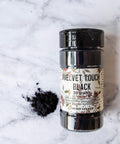 Black Velvet Touch bottle with a small pile of the velvet powder next to it.