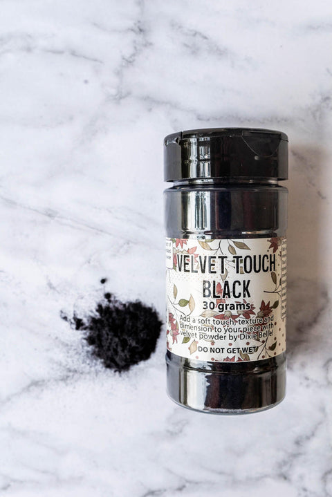 Black Velvet Touch bottle with a small pile of the velvet powder next to it.