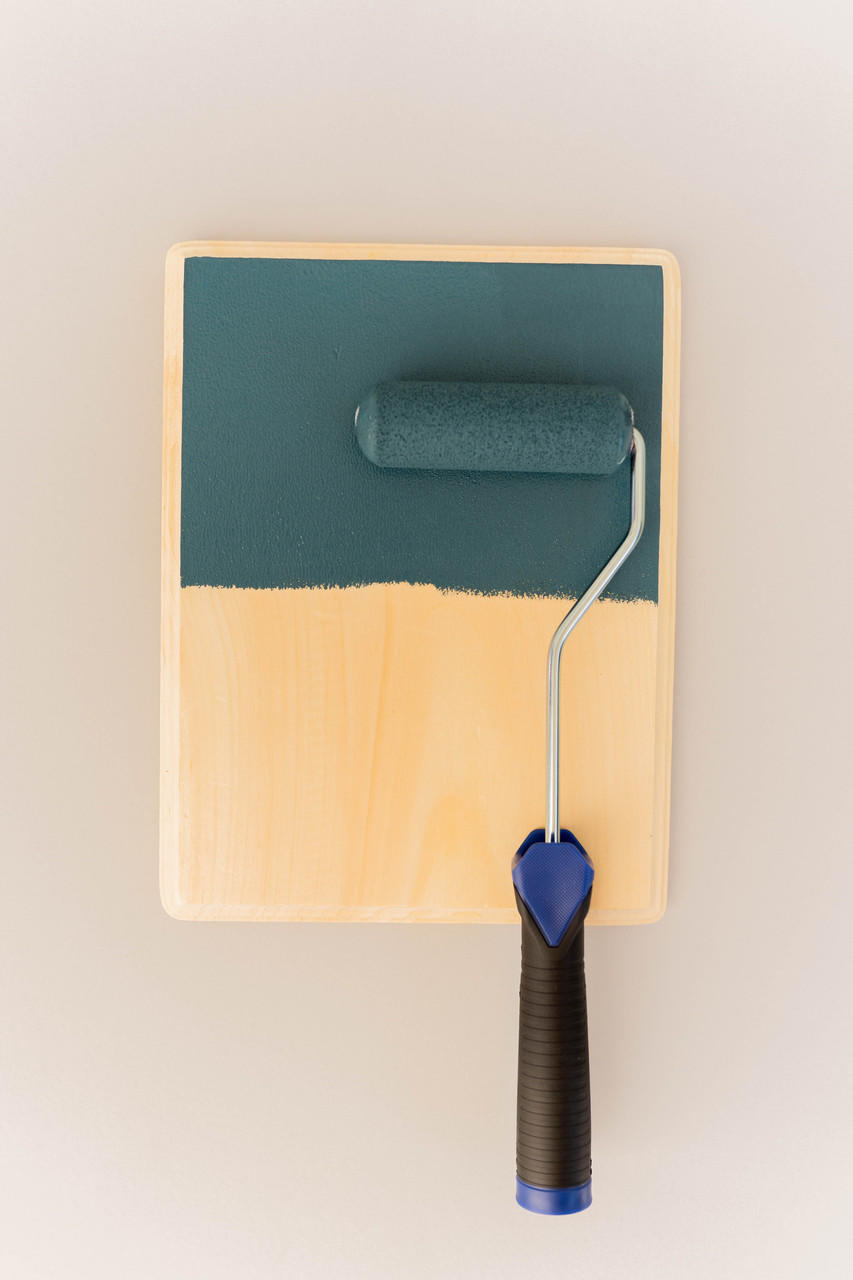Smooth Roller being used on a wood board with a greenish blue paint.