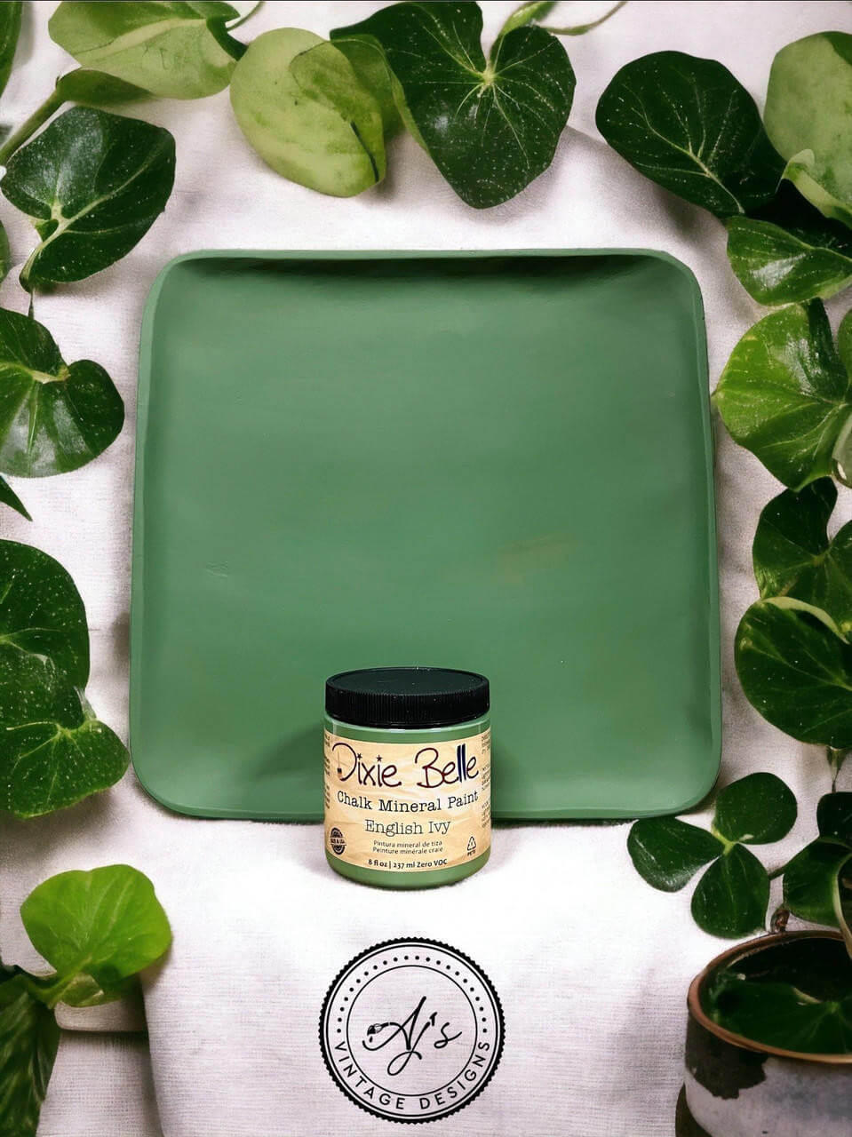 Wooden tray painted with English Ivy Chalk Mineral Paint. Staged with green leaves surrounding the wooden tray and paint jar.