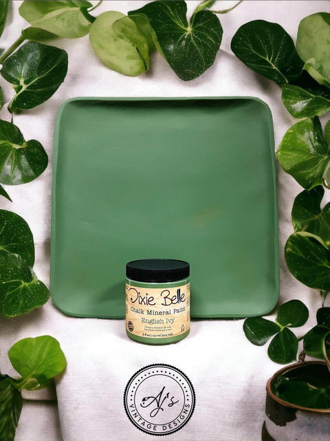 Wooden tray painted with English Ivy Chalk Mineral Paint. Staged with green leaves surrounding the wooden tray and paint jar.