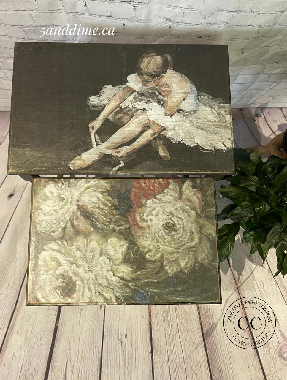 Nesting tables with a decoupage of a ballerina tying her shoes on the top table is open, and a floral design on the bottom table. The tables are on a light wooden floor next to a green plant. The text "5anddime.ca" is on the lid.