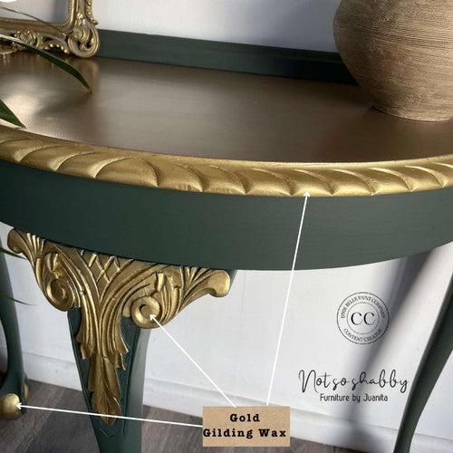 A close-up of a green and gold ornate table with intricate gold detailing on the edge and leg, labeled "Gold Gilding Wax." A round beige vase and a plant sit on top. A "Not so shabby furniture by Juanita" watermark appears on the side.