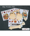 A craft kit labeled "Hey Punkin Kit" includes autumn-themed floral and pumpkin transfers, unfinished wood cutouts in various shapes, and a wooden sign reading "AUTUMN," all displayed on a dark background.