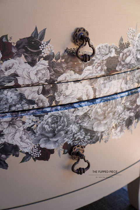 A close-up of a curved chest of drawers with Monochrome Majesty Transfer applied and ornate black metal handles.