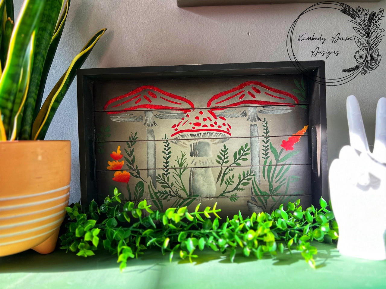 Dark brown chalk painted wood serving tray. Moonlit Mushrooms Stencil applied on the base of the tray with white stems and red caps as well as green leaves and orangish red flowers.