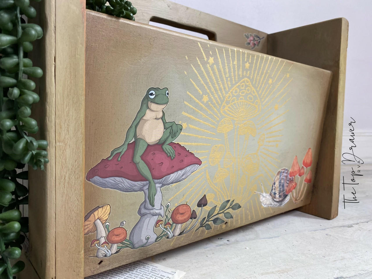 Wooden magazine holder with Mr. Toad's Transfer applied on the front of one of the sides. Staged with a faux string of pearls hanging off the side.