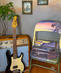 Purple, pink, yellow, and green painted foldable chair. The Rusty Truck Transfer has been applied to the seat and back of the chair. Staged next to a vintage speaker and guitar.