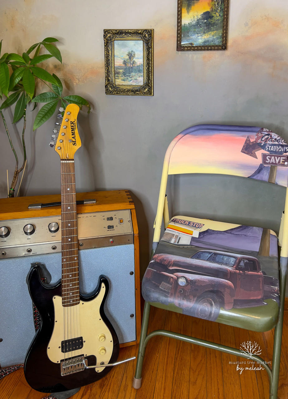 Purple, pink, yellow, and green painted foldable chair. The Rusty Truck Transfer has been applied to the seat and back of the chair. Staged next to a vintage speaker and guitar.